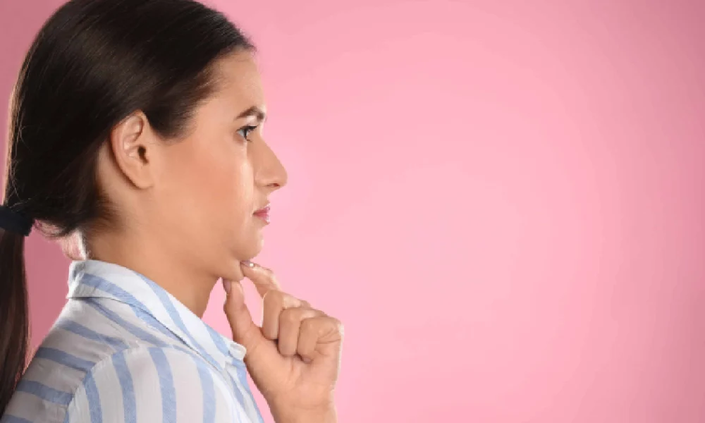 Woman in profile touching her chin, highlighting submental area for Kybella in Columbia, SC
